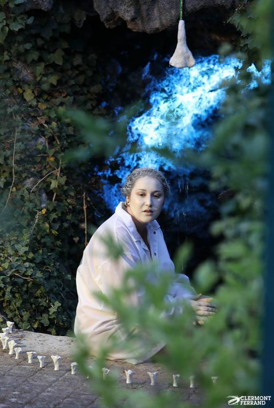 Clélia est à l'entrée de la grotte, elle est peinte en blanc et porte un imperméable blanc. On voit au-dessus d'elle un pommeau de douche en forme de chanterelle qui laisse échapper un filet d'eau. Des chanterelles blanches l'encercle